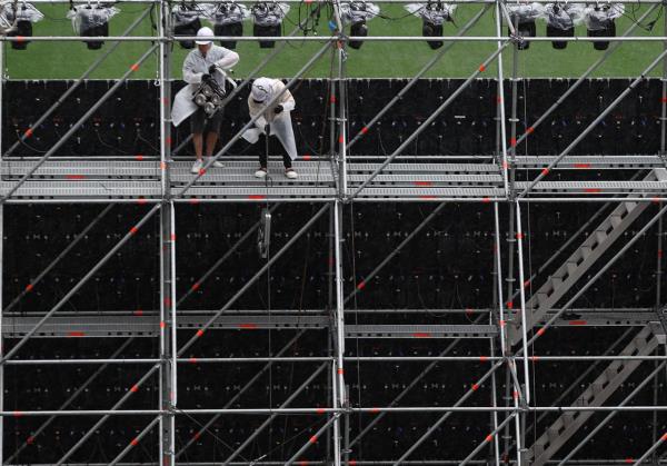 Workers install a makeshift stage for the 